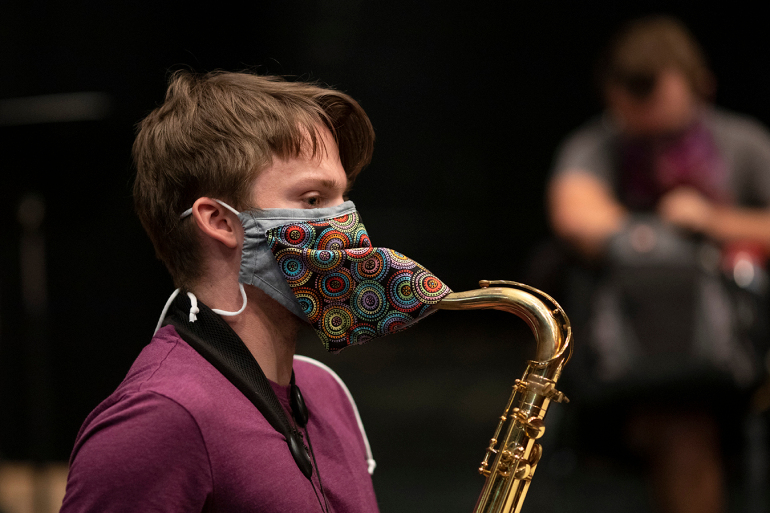 A college student wears a custom-designed mask during rehearsal at Indiana University Jacobs School of Music in Bloomington, Indiana. (Chris Bergin for KHN)